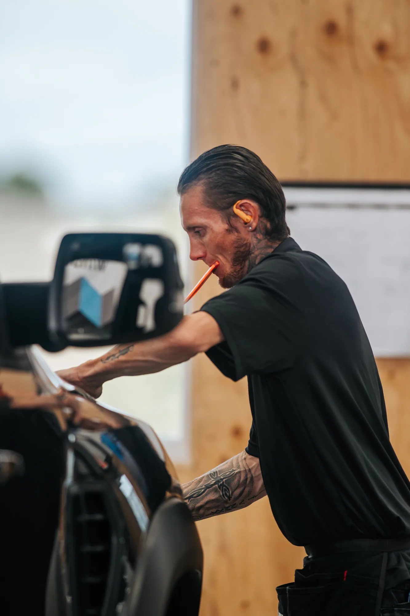 Candid of a tint installer working a side mirror, manual focus on a 1981 Canon lens