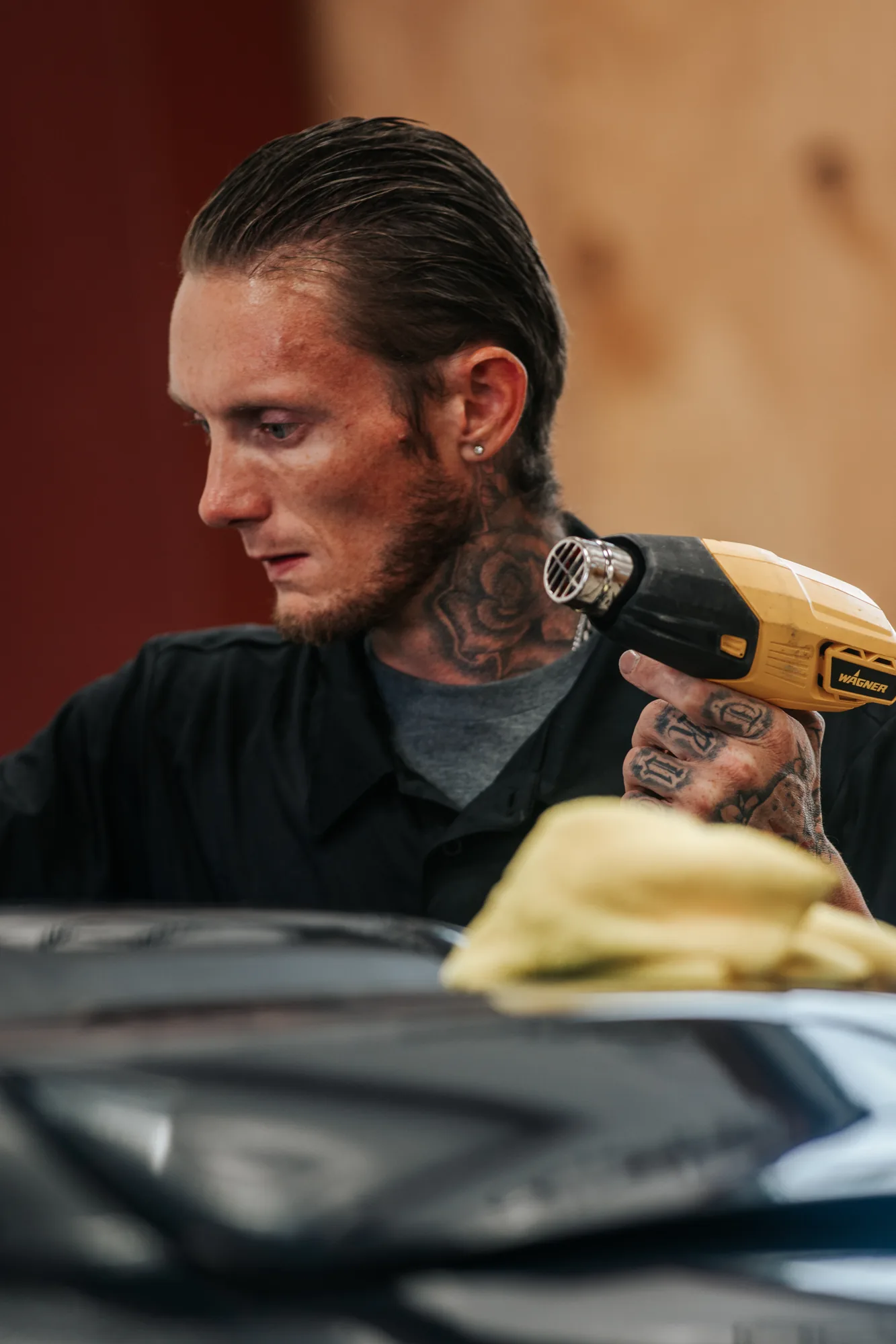 Installer with a heat gun shaping window film, candid on the Canon FD 300mm