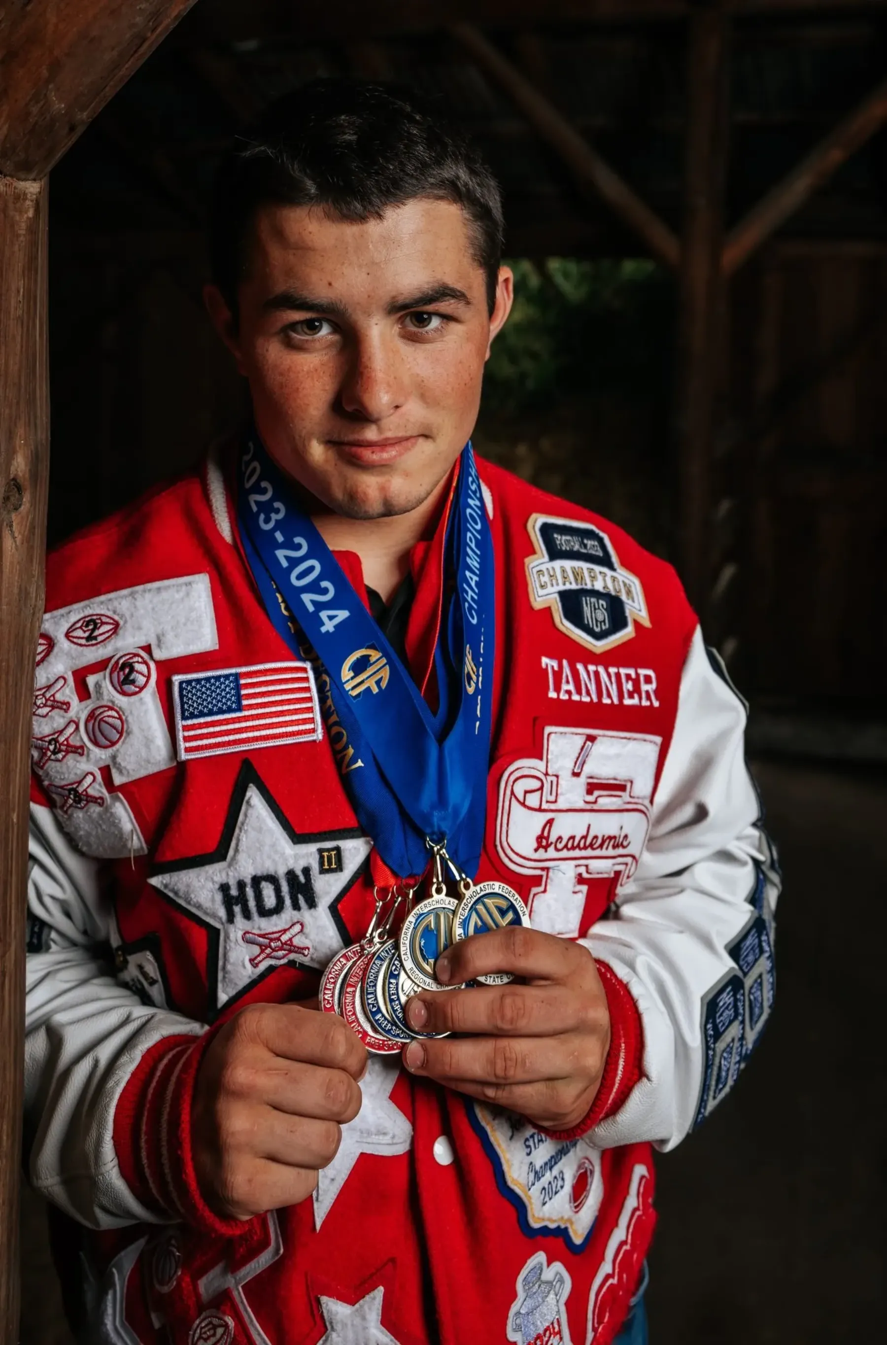 Tanner Pidgeon showing off his hard-earned medals during Ferndale High School senior portraits by Tex Kelly Productions
