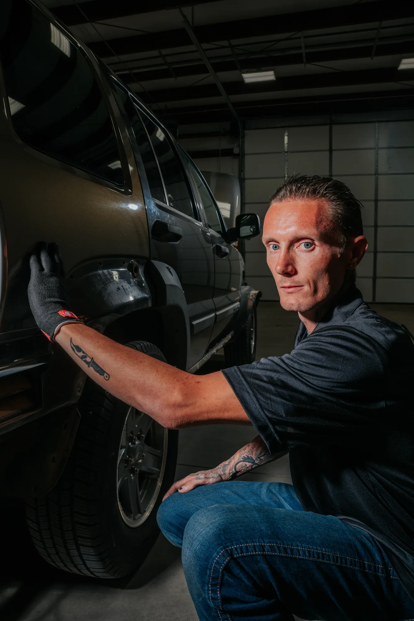 Jonny Martin kneeling at a Jeep door during a window tint install