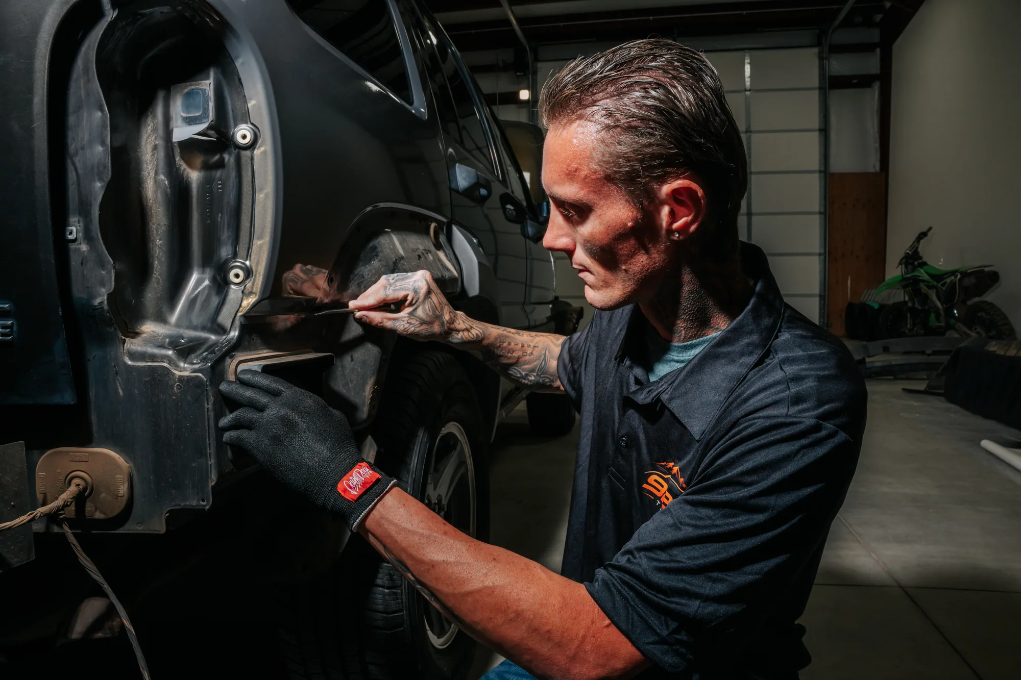Jonny Martin trimming window film along a Jeep door at 928 Tint