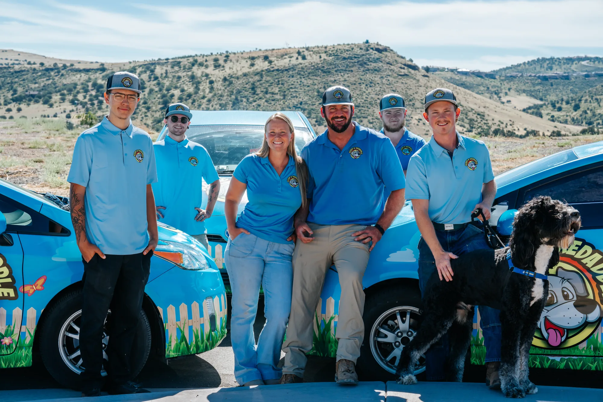 Team portrait for Scoop & Skedaddle, a Prescott Valley pet waste removal company, beside their wrapped company car