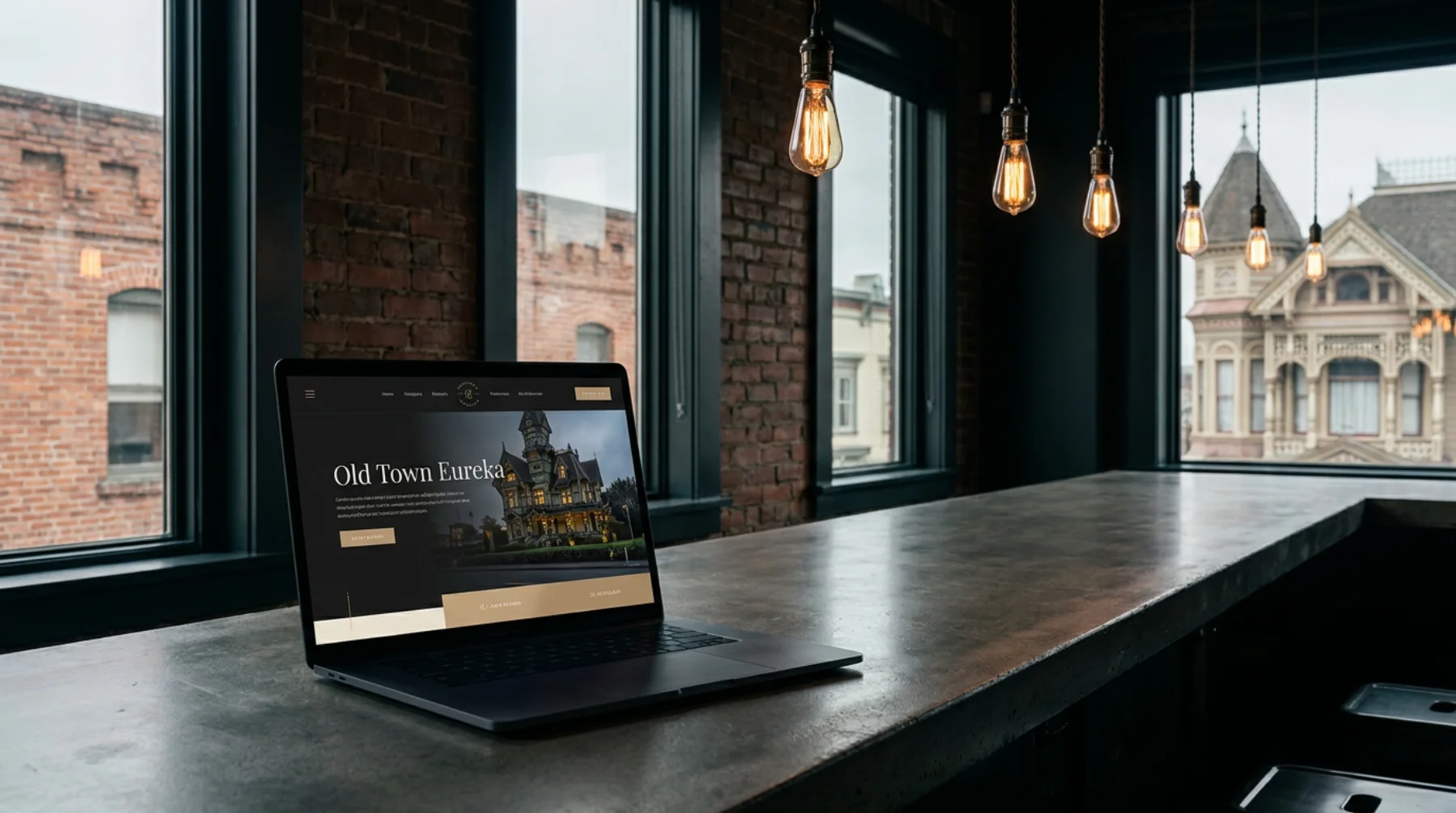 Hand-coded website on a laptop in Old Town Eureka. Carson Mansion through a rain-glossed window