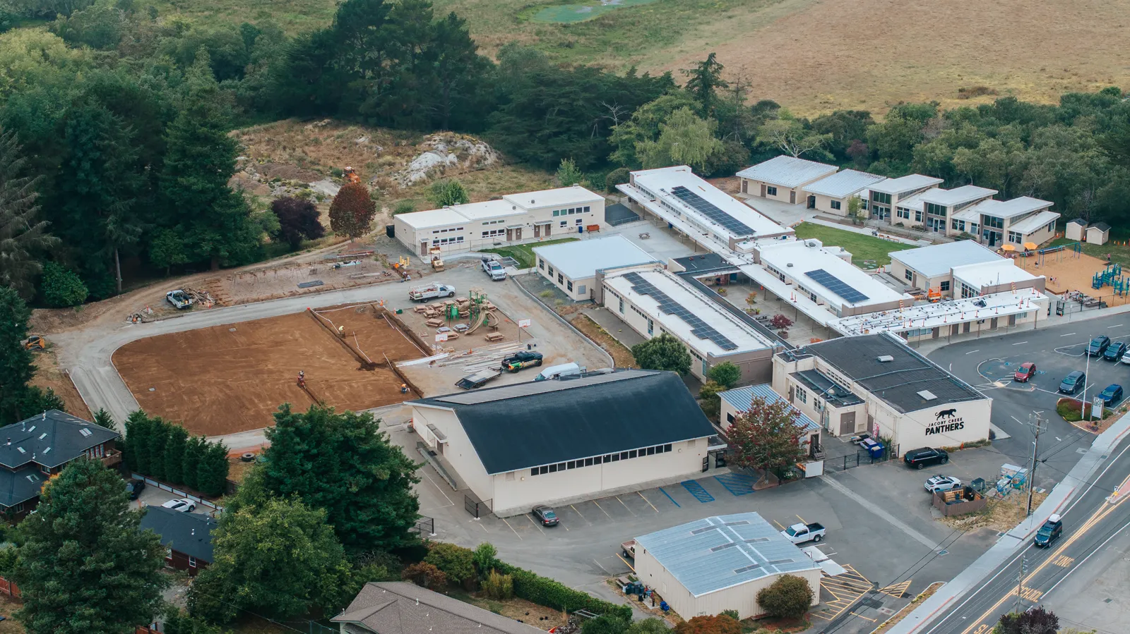 School campus with rooftop solar and field construction from drone elevation. Drone Photography and Videography by Tex Kelly Productions, serving Williams, Arizona.