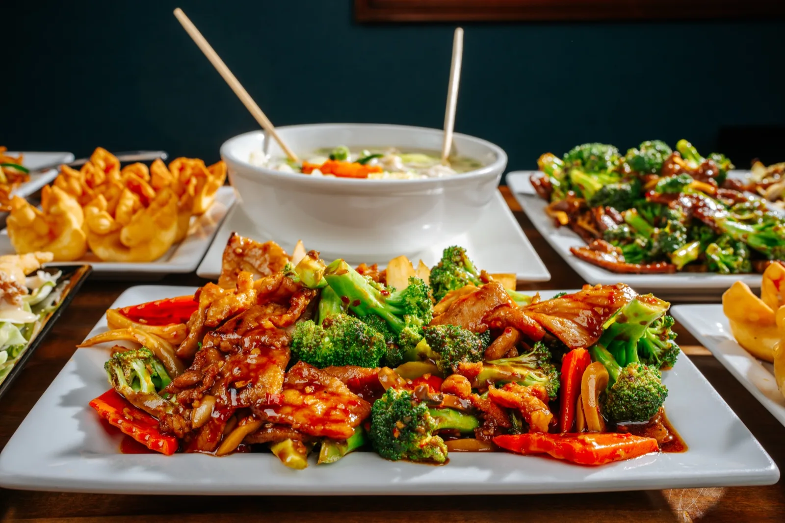 Hunan Chinese Restaurant, multi-plate house spread with cabbage stir-fry, dumplings, and broccoli protein