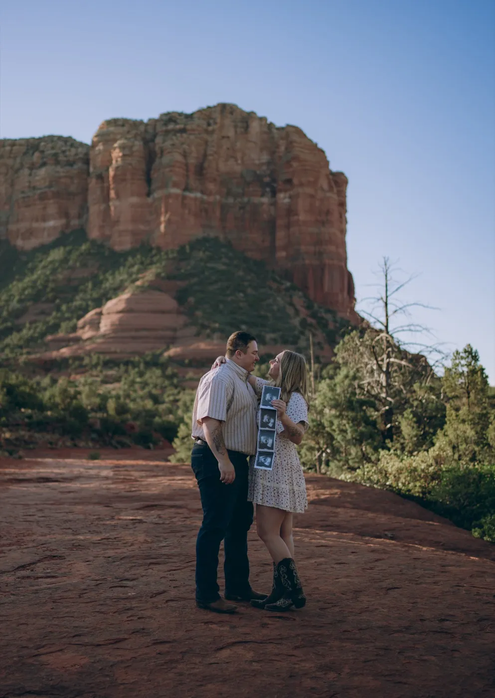 A couple holding a sonogram for a baby announcement in Sedona, photographed by Tex Kelly