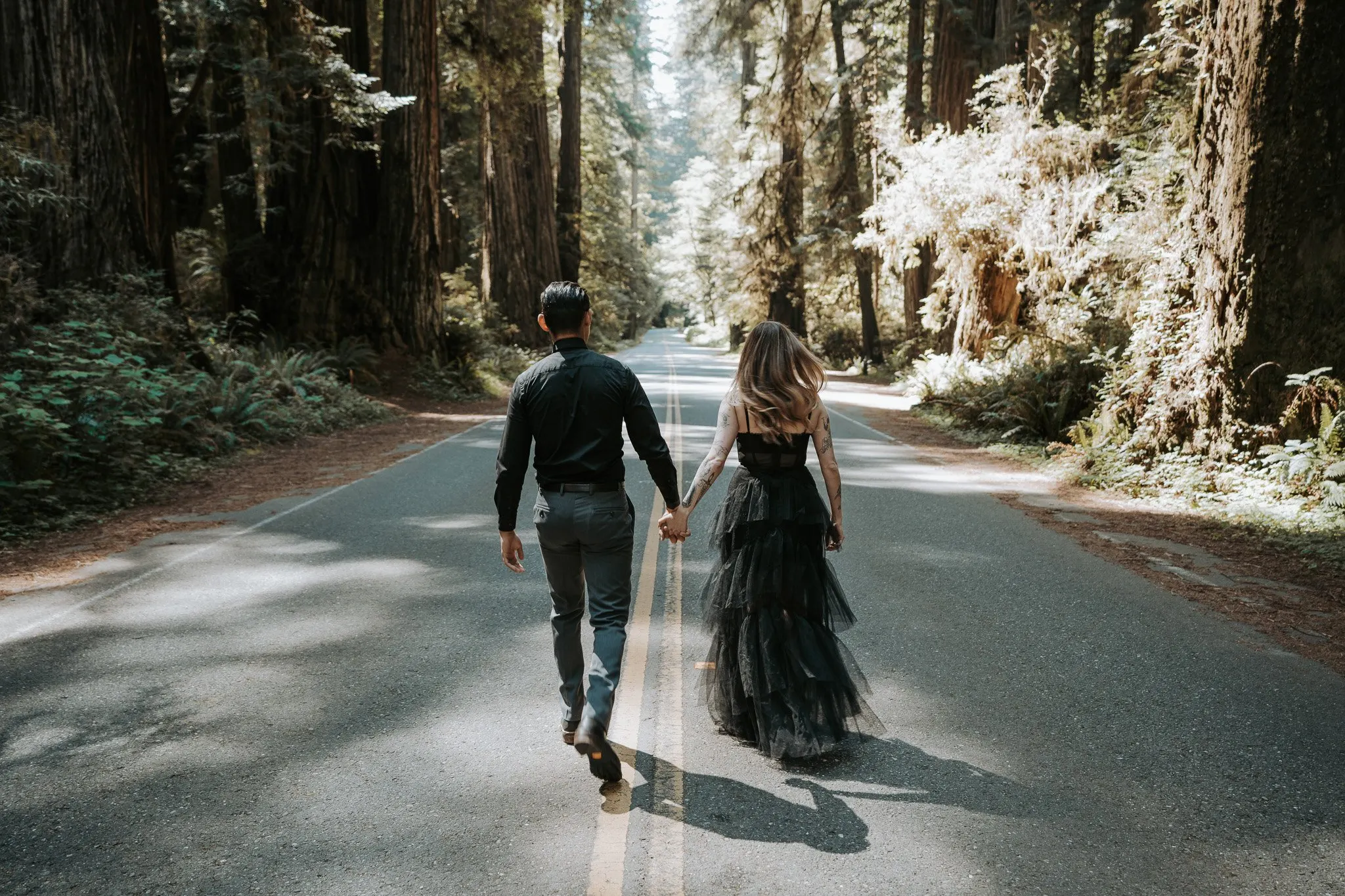Couple holding hands on a forested ridge
