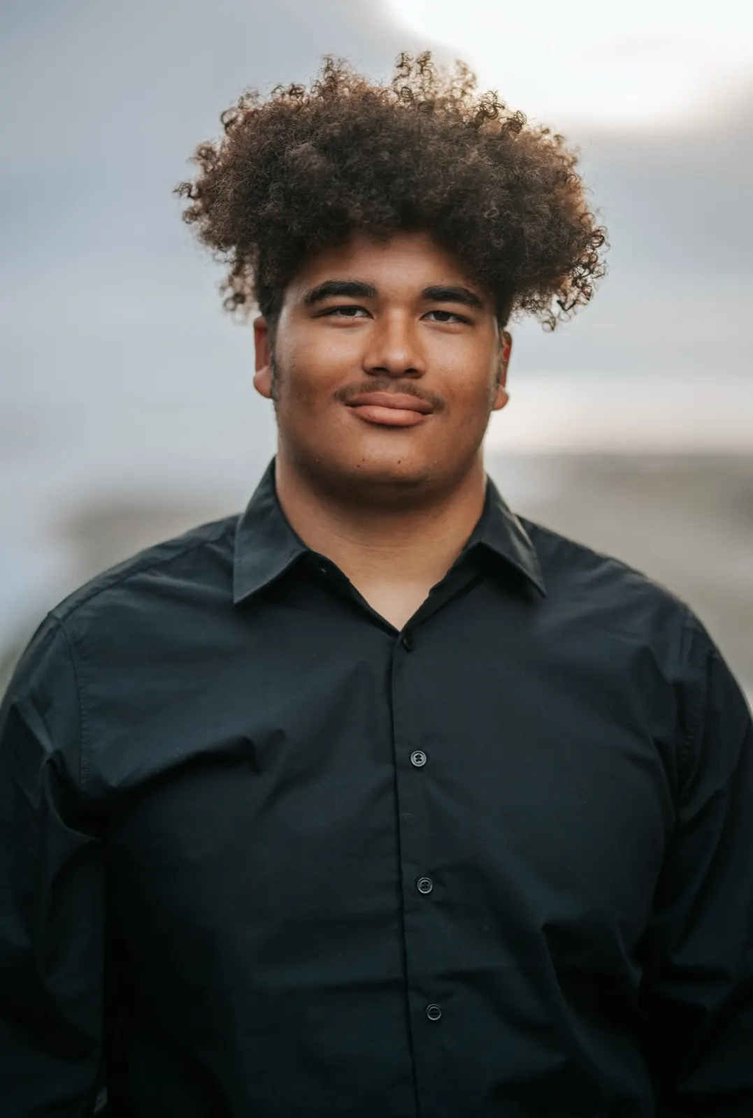 Senior in formal attire on a coastal trail