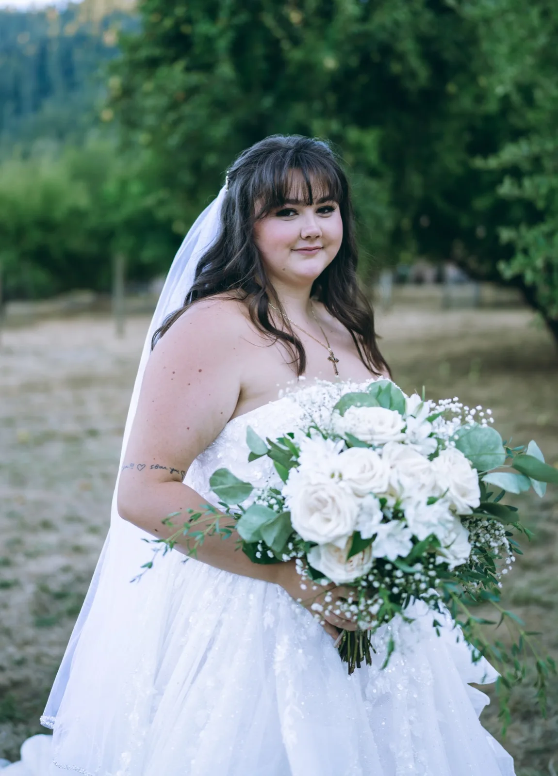 Editorial bridal portrait with white-rose bouquet in a North Coast orchard at golden hour