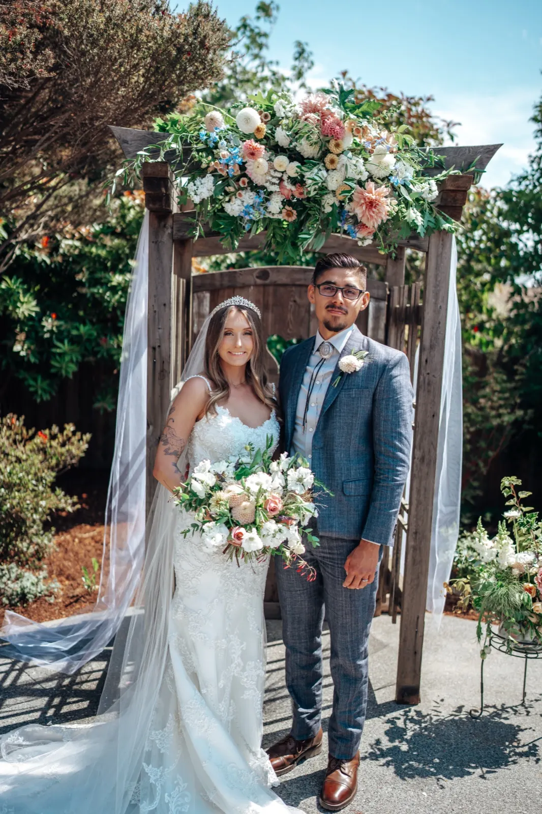 Bethany and Chris ceremony portrait under a floral arch