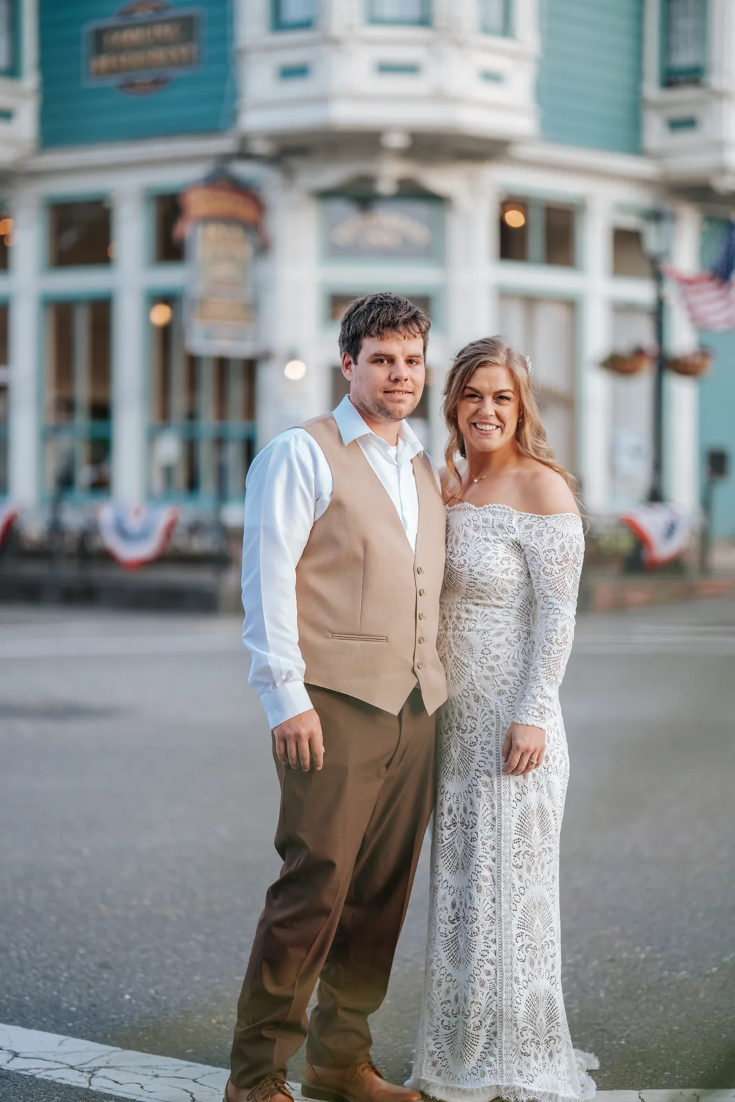 Bride and groom portrait on a small-town main street in front of a Victorian storefront