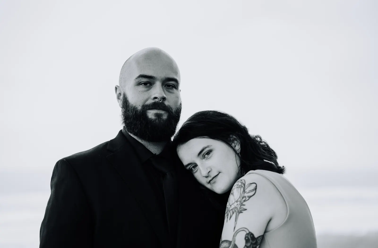 Black-and-white editorial couple portrait at the coast