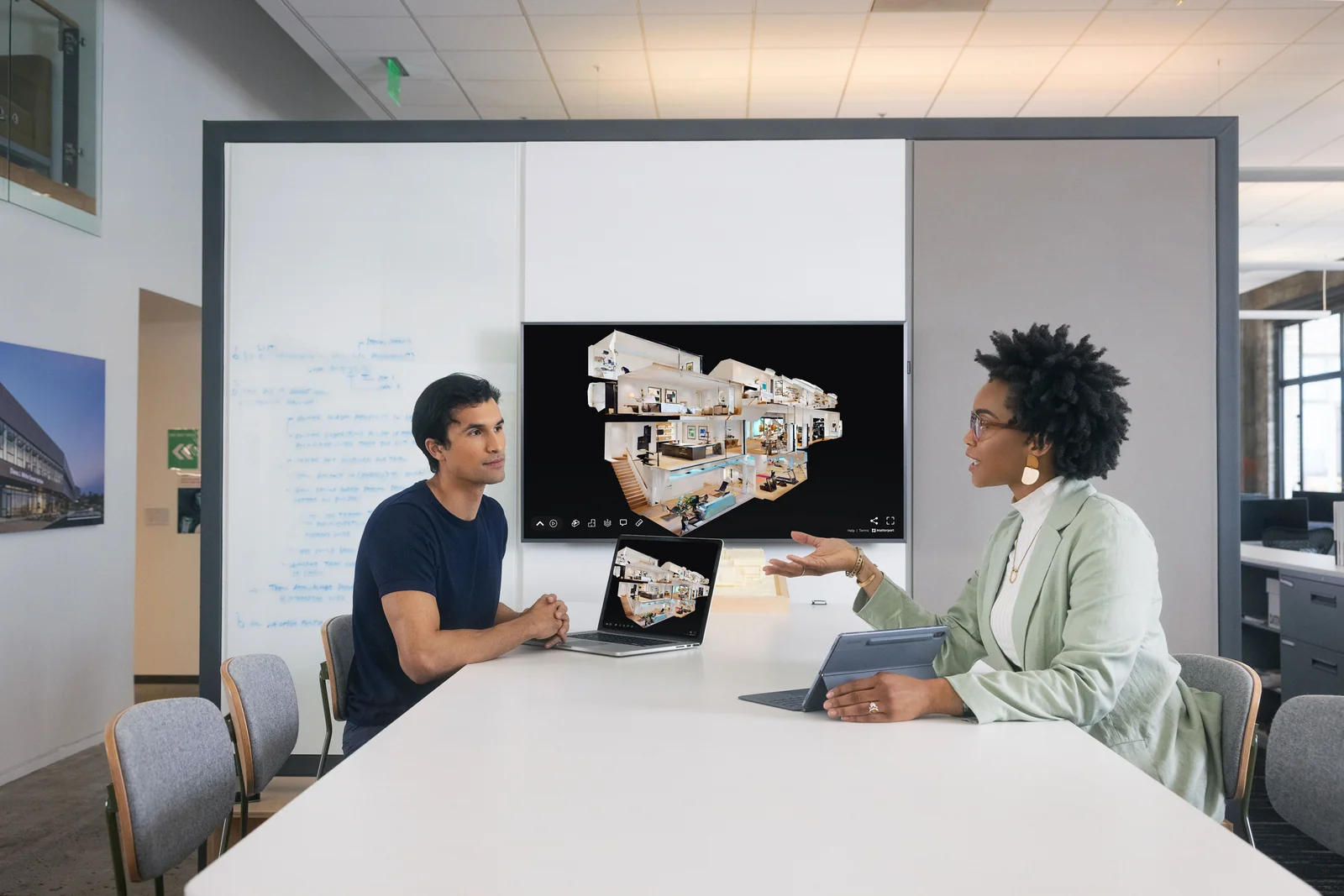 Architects and project managers collaborating around a Matterport dollhouse model of an existing building (photo via Matterport partner materials)